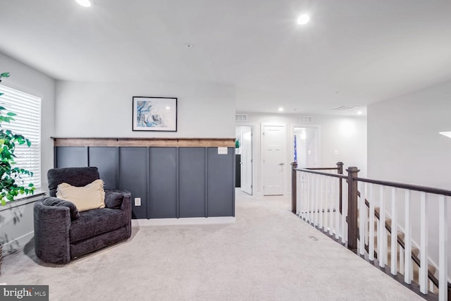 sitting room featuring light carpet