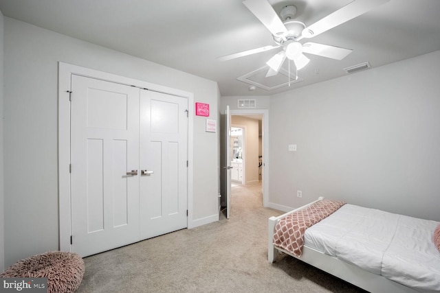 bedroom featuring ceiling fan, light carpet, and a closet