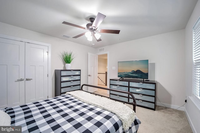 bedroom featuring a closet, ceiling fan, and light colored carpet