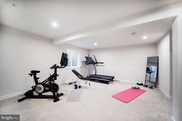 workout room featuring light carpet