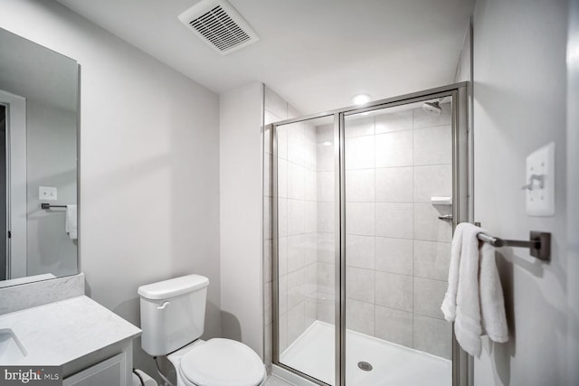 bathroom with vanity, toilet, and a shower with shower door