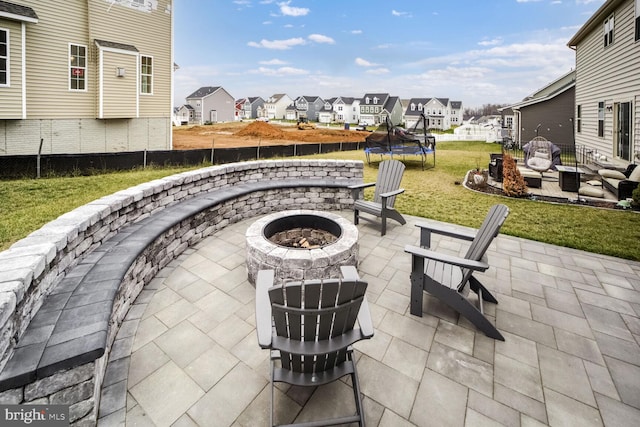 view of patio / terrace featuring a trampoline and an outdoor fire pit