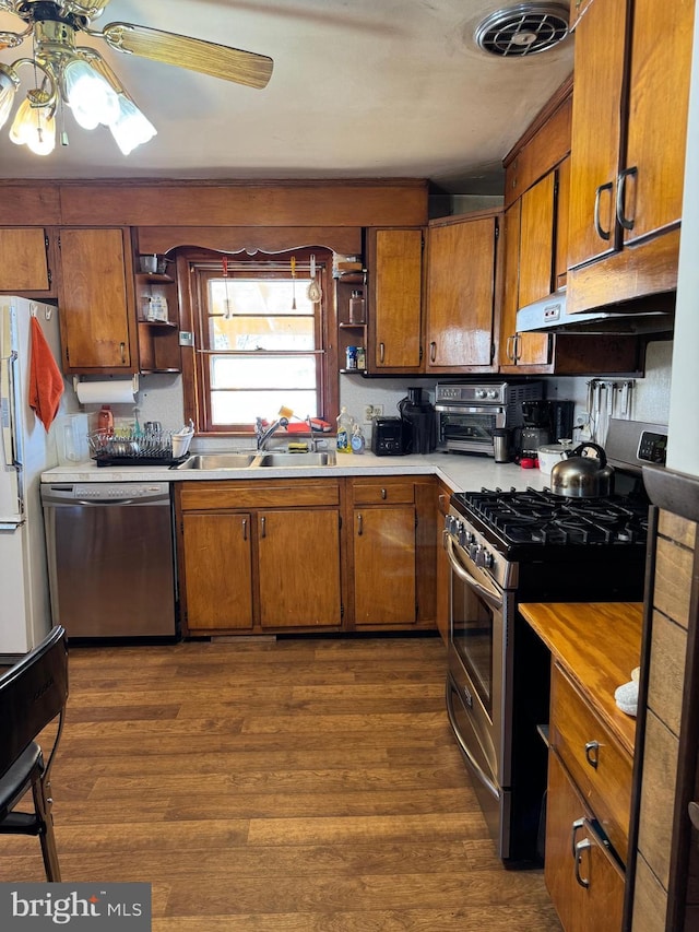 kitchen with ceiling fan, sink, dark wood-type flooring, and appliances with stainless steel finishes