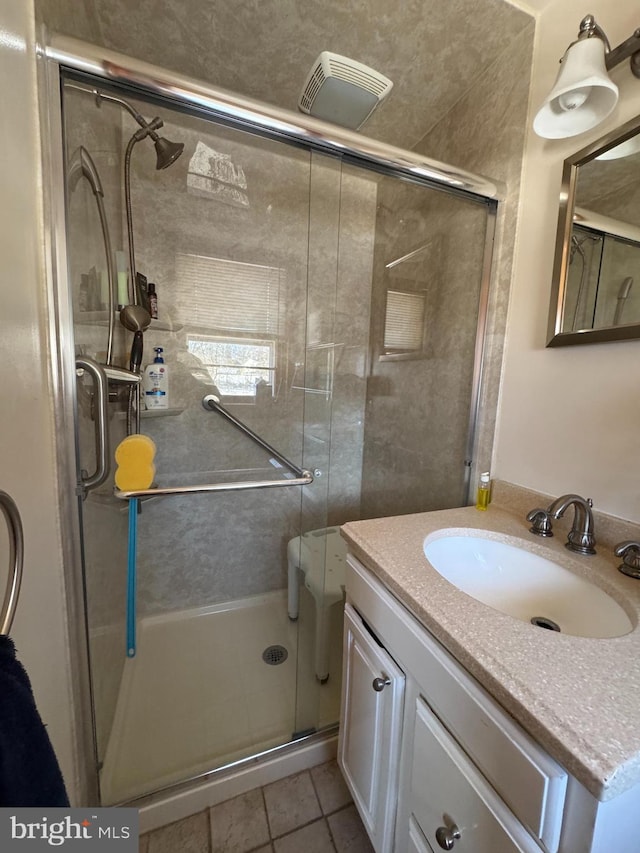 bathroom with tile patterned floors, vanity, and an enclosed shower