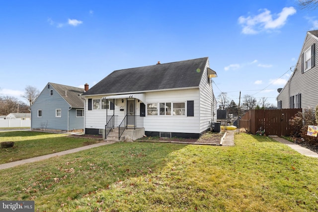 bungalow with cooling unit and a front lawn