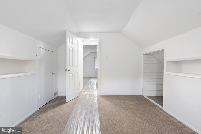 bonus room with vaulted ceiling and carpet