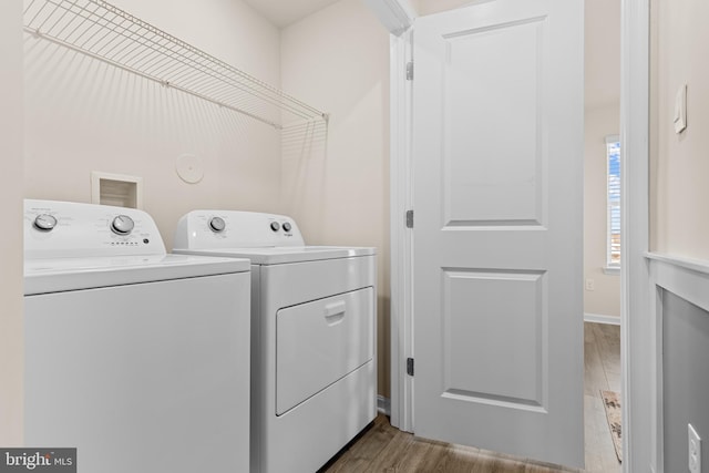 washroom with light hardwood / wood-style flooring and washing machine and clothes dryer