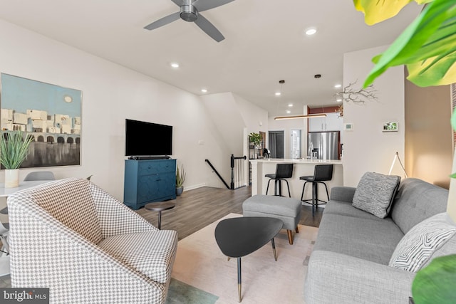 living room featuring ceiling fan and hardwood / wood-style floors