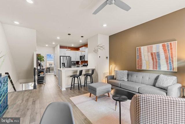 living room featuring light hardwood / wood-style floors and ceiling fan