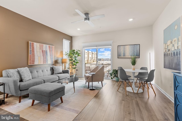 living room featuring ceiling fan and light wood-type flooring