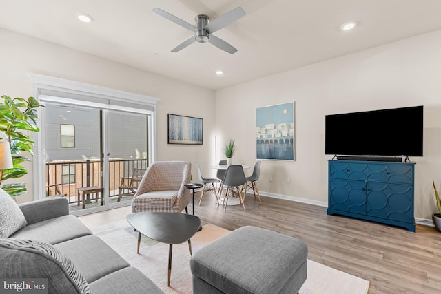 living room featuring ceiling fan and light hardwood / wood-style floors