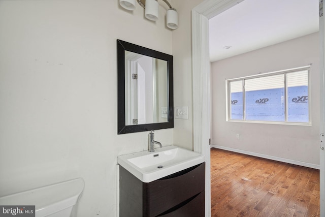 bathroom with hardwood / wood-style floors, vanity, and toilet