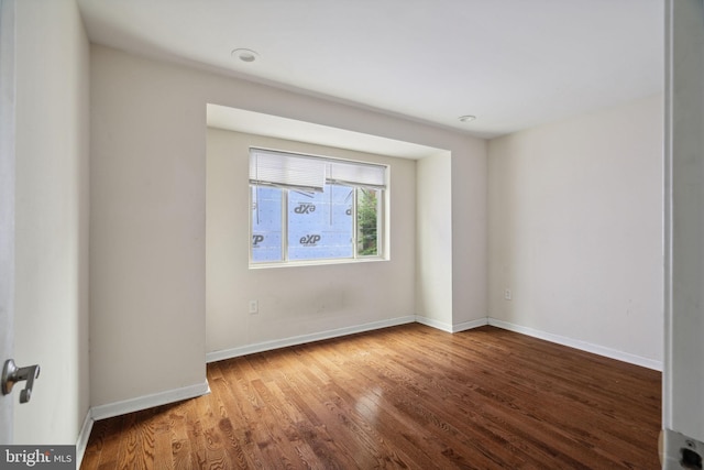 unfurnished room with hardwood / wood-style floors