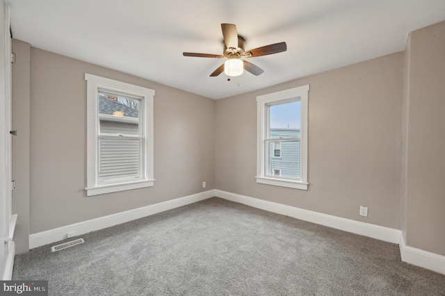 carpeted spare room featuring ceiling fan