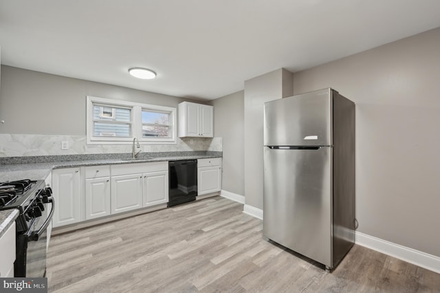 kitchen with sink, light stone counters, decorative backsplash, white cabinets, and appliances with stainless steel finishes