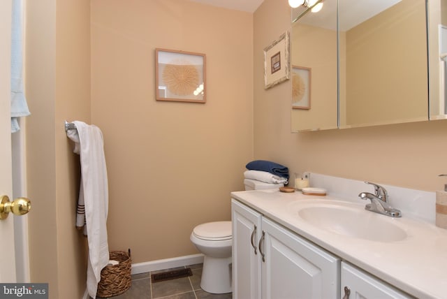 bathroom with tile patterned flooring, vanity, and toilet