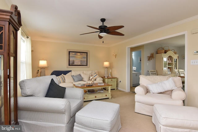 living room featuring light colored carpet, ceiling fan, and ornamental molding