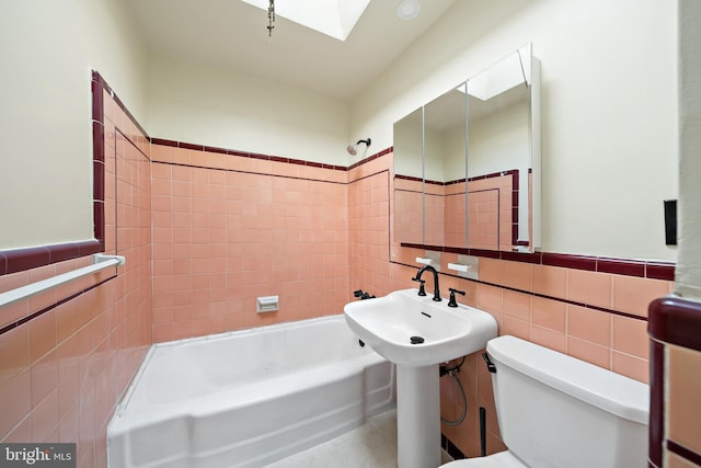 bathroom featuring tile patterned flooring, toilet, tile walls, and tiled shower / bath