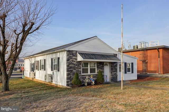 view of front of home featuring ac unit and a front lawn