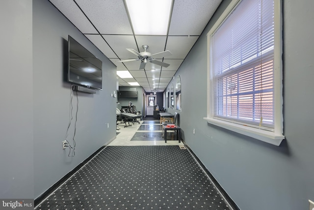 corridor with carpet, a paneled ceiling, and a wall unit AC