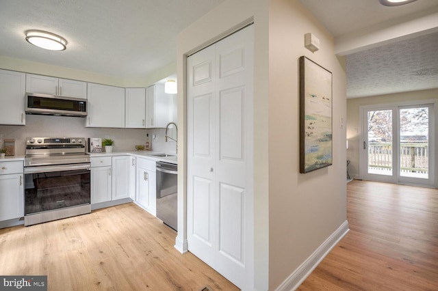 kitchen featuring white cabinets, light hardwood / wood-style floors, sink, and appliances with stainless steel finishes