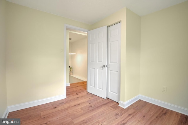 unfurnished bedroom featuring light hardwood / wood-style flooring and a closet