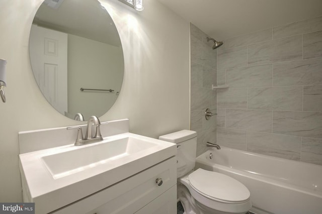 full bathroom featuring tiled shower / bath combo, toilet, and vanity