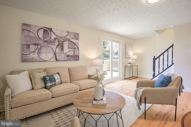 living room featuring a textured ceiling and light hardwood / wood-style flooring