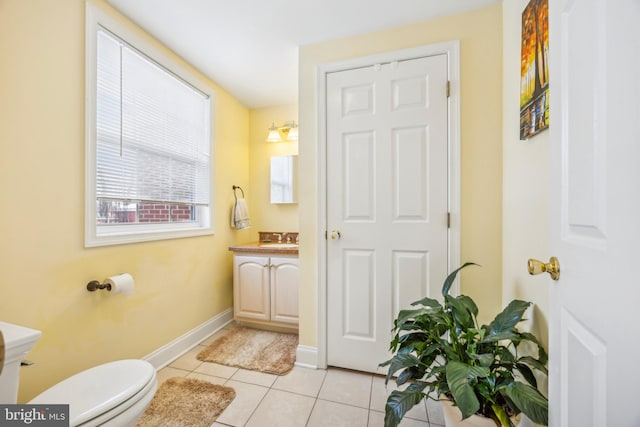 bathroom with toilet, vanity, and tile patterned flooring