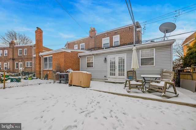 view of snow covered back of property