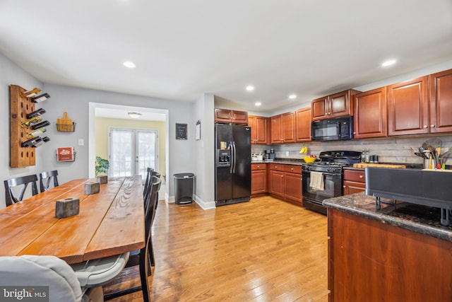 kitchen featuring black appliances, tasteful backsplash, light wood-type flooring, and french doors