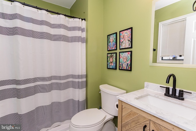 bathroom featuring curtained shower, vanity, and toilet