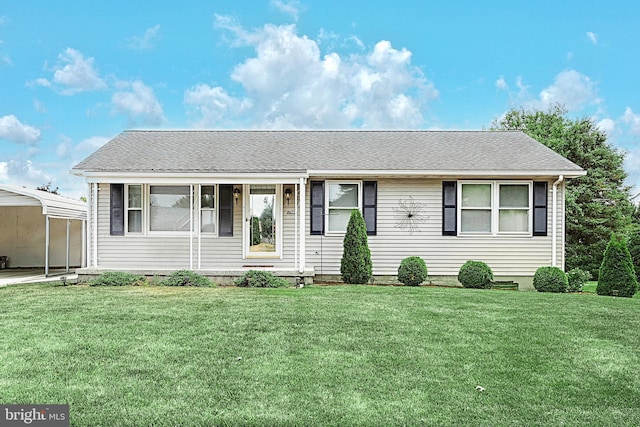 view of front of home with a carport and a front lawn