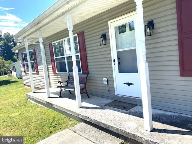 view of exterior entry featuring covered porch