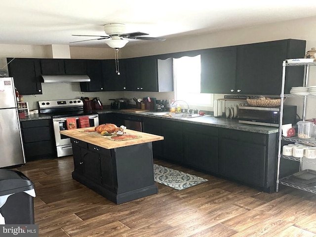 kitchen featuring hardwood / wood-style floors, appliances with stainless steel finishes, a kitchen island, and sink