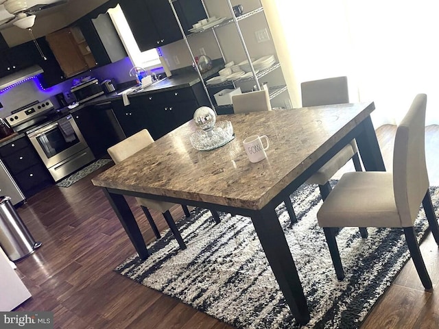 dining area with ceiling fan and dark wood-type flooring