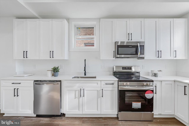 kitchen featuring dark wood-type flooring, white cabinetry, sink, and stainless steel appliances