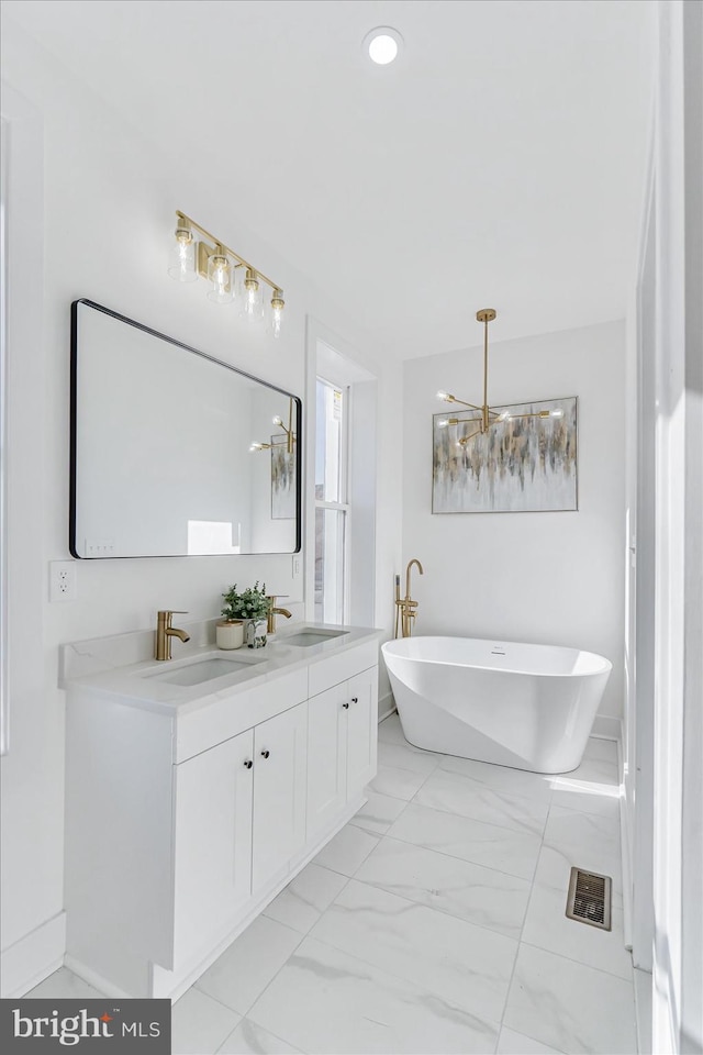 bathroom featuring a notable chandelier, a bathtub, and vanity