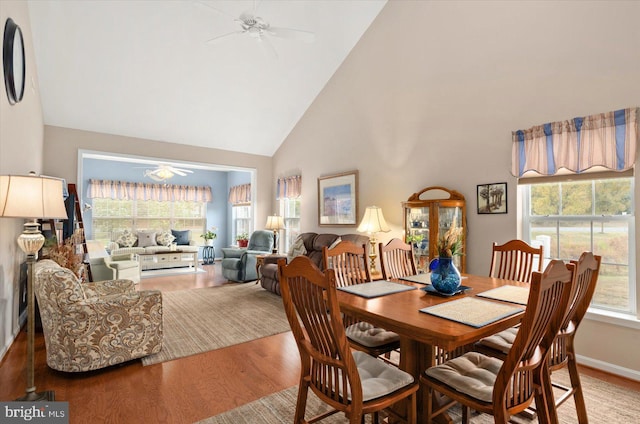 dining room featuring hardwood / wood-style flooring, ceiling fan, and high vaulted ceiling