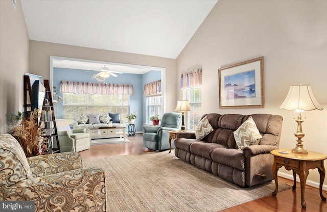 living room with ceiling fan, wood-type flooring, and vaulted ceiling