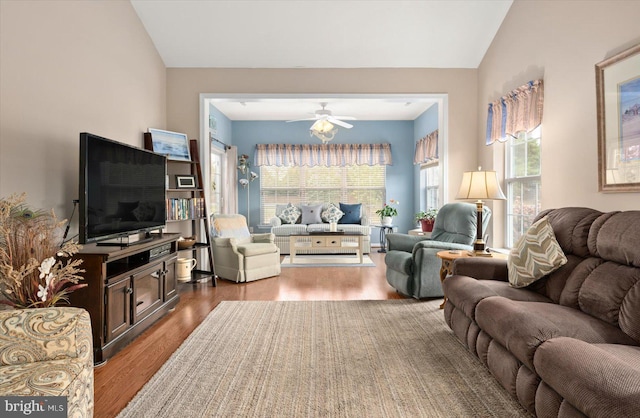 living room featuring a wealth of natural light, ceiling fan, lofted ceiling, and hardwood / wood-style flooring