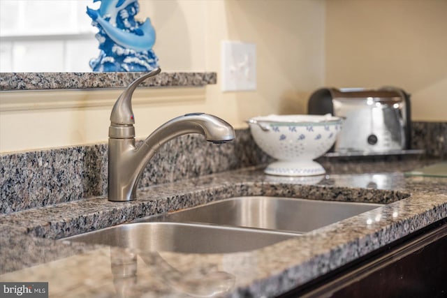 room details with dark stone countertops and sink