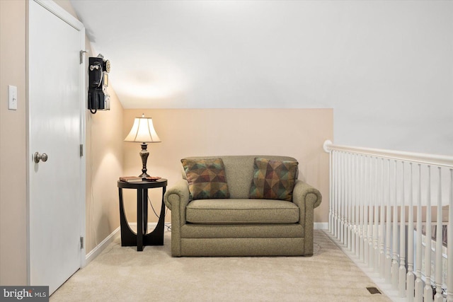 living area featuring light colored carpet and vaulted ceiling