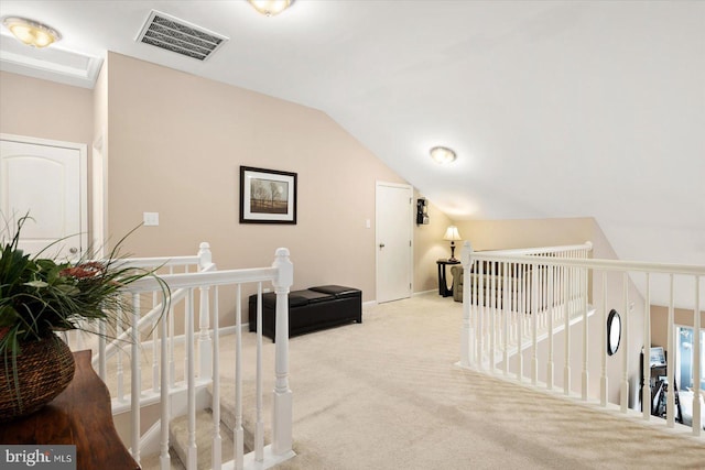 hallway featuring light colored carpet and vaulted ceiling