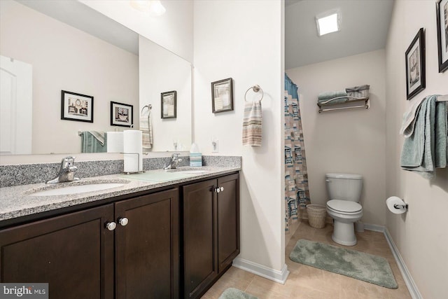 bathroom with tile patterned flooring, vanity, and toilet