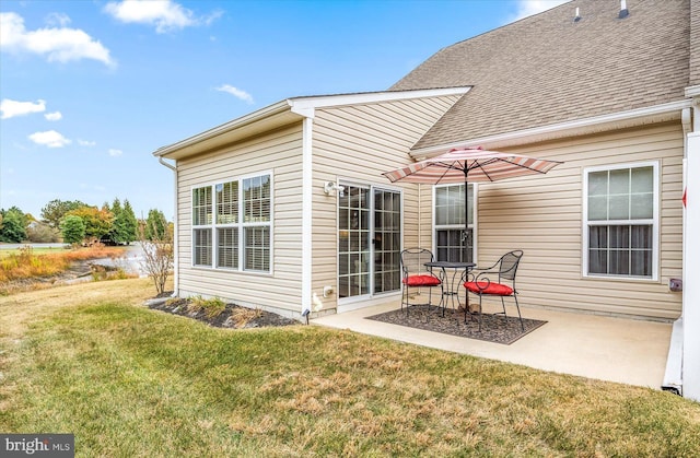 rear view of property with a yard and a patio