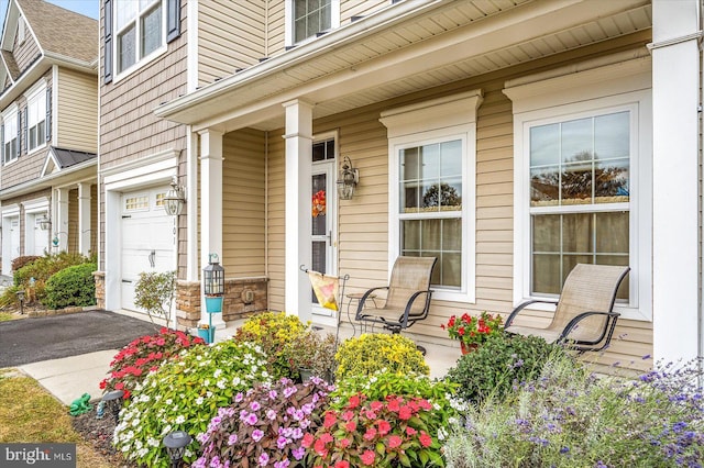 entrance to property featuring a porch and a garage