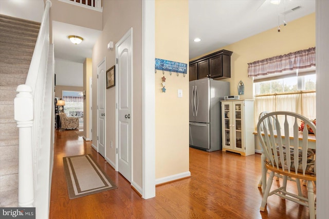 kitchen with hardwood / wood-style flooring, dark brown cabinetry, and stainless steel refrigerator