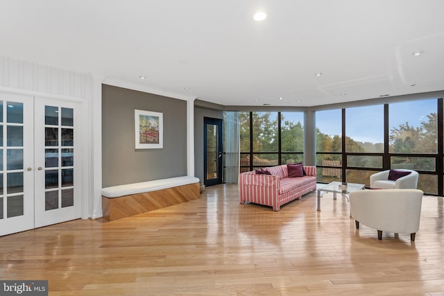 living room featuring floor to ceiling windows, light hardwood / wood-style floors, and french doors