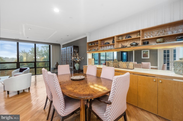 dining room featuring expansive windows, light hardwood / wood-style floors, and ornamental molding